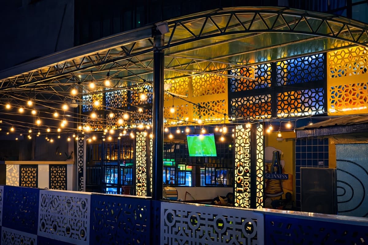 LSG bar exterior with string lights and decorative panels at night